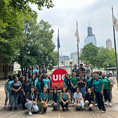 Students on the UIC campus with the Chicago skyline in the backround